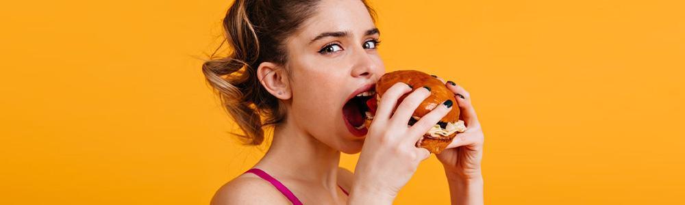 Mujer comiendo hambuerguesa